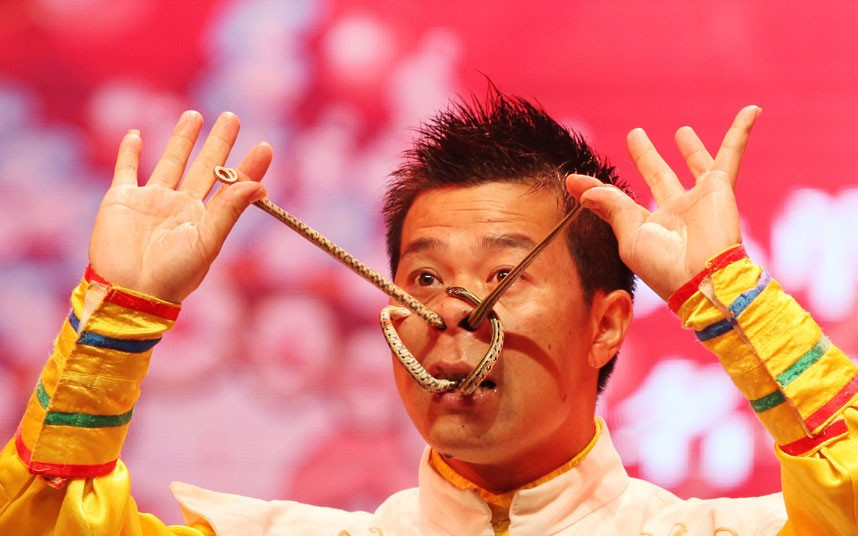 Những hình ảnh ấn tượng trong tuần ảnh 6 Stunt performer Liu Hong winds snakes through his nose and mouth at a folk artist stunt competition in Yongchun, Chongqing Municipality, China
