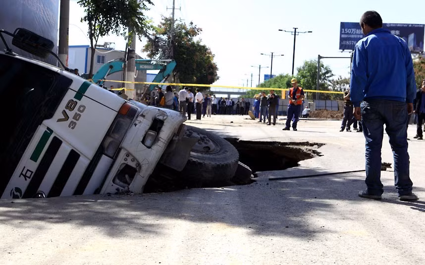 A cement mixer is trapped in a hole in Xi’an, China. A section of the Taihua North Road caved in, engulfing a passing cement mixer and breaking an underground natural gas pipeline.