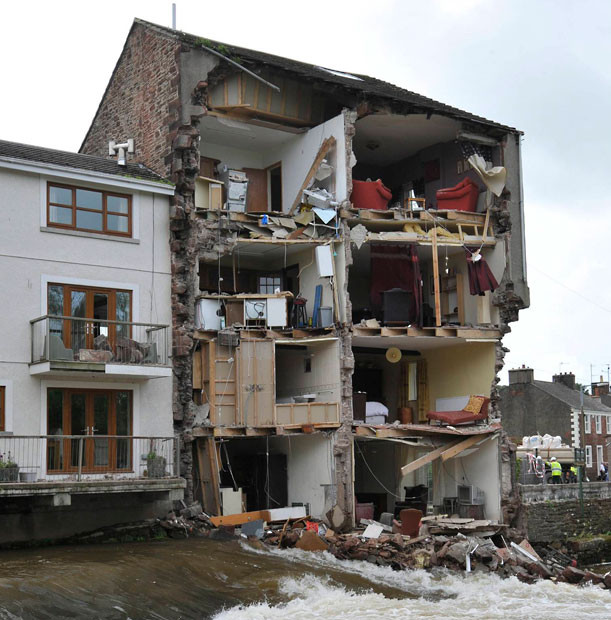 It looks like a real-life dolls house but this is the terrifying scene after the whole side of a house was washed away by a swollen river. The end-terrace house dramatically crumbled into the rain-swollen River Ehen in Vale View, Egremont, Cumbria. Thankfully the family escaped alive as they had been staying at another property.