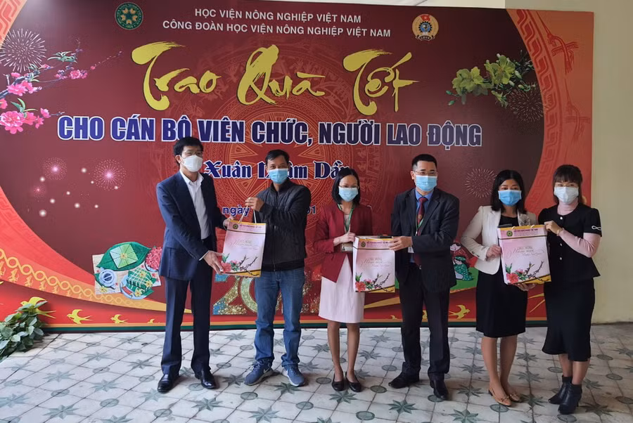 PGS.TS Phạm Bảo Dương (thứ 3 từ phải sang trái) và TS Nguyễn Tất Thắng (ngoài cùng bên trái) trao quà Tết cho cán bộ, viên chức, người lao động.