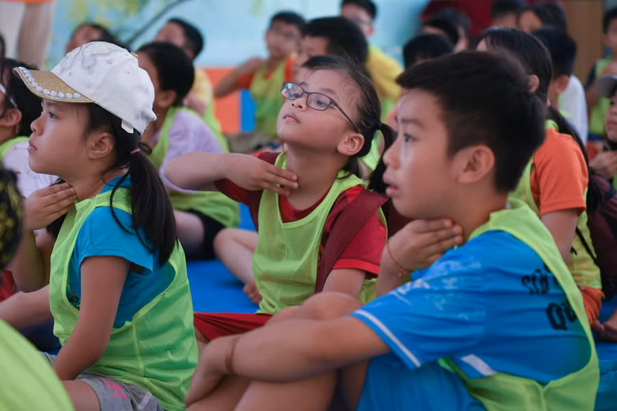 Các bạn nhỏ thực hành đặt tay lên vùng cổ để kiểm tra bước đầu với trường hợp tim ngừng đập. (Ảnh: Lê Nghĩa)