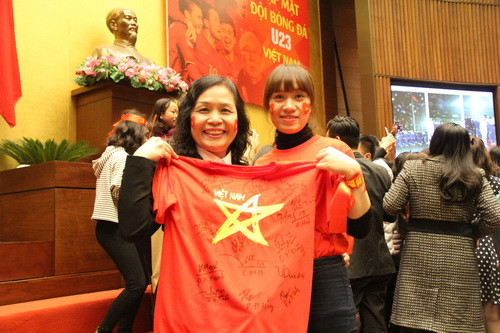 Hai mẹ con rạng người niềm vui vì xin được rất nhiều chữ ký của các cầu thủ