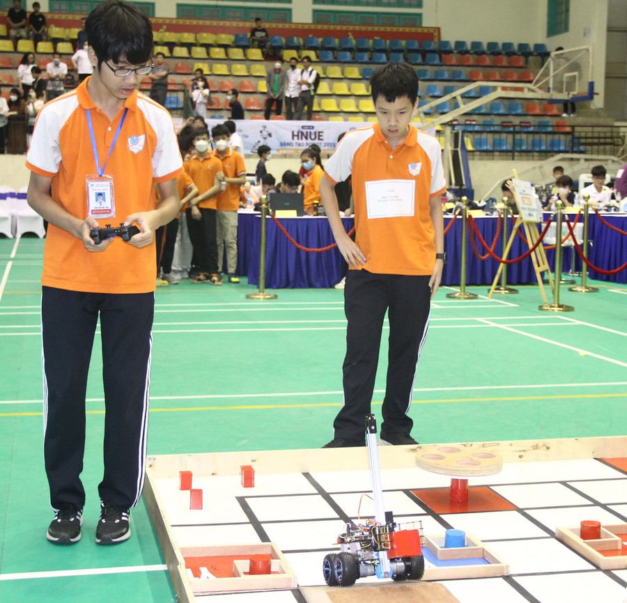 Đào Phú Bảo, lớp 7A7 và Đặng Trần Nhất Long (bên trái), lớp 8A7 đến từ Trường THCS&THPT Nguyễn Tất Thành (Hà Nội) điều khiển robot thực hiện các nhiệm vụ trong phần thi của mình. Đào Phú Bảo, lớp 7A7 và Đặng Trần Nhất Long (bên trái), lớp 8A7 đến từ Trường THCS&THPT Nguyễn Tất Thành (Hà Nội) điều khiển robot thực hiện các nhiệm vụ trong phần thi của mình.