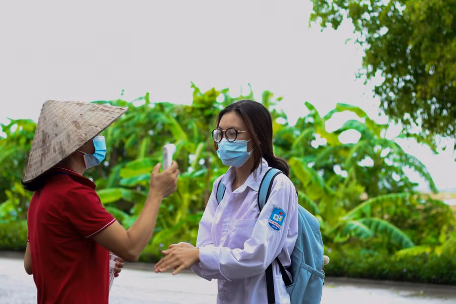 Công tác khử khuẩn, đo thân nhiệt cho các thí sinh được thực hiện từ vòng ngoài.