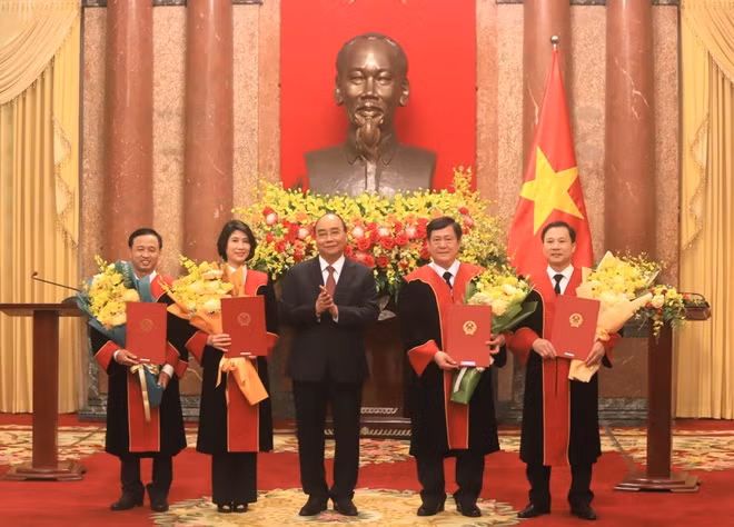 Chủ tịch nước Nguyễn Xuân Phúc trao quyết định bổ nhiệm và tặng hoa chúc mừng 4 tân thẩm phán TAND Tối cao. Ảnh: H. Vũ.