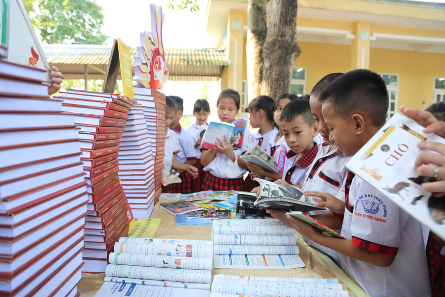 Các em học sinh chăm chú tham quan đọc sách tại các gian trưng bày.