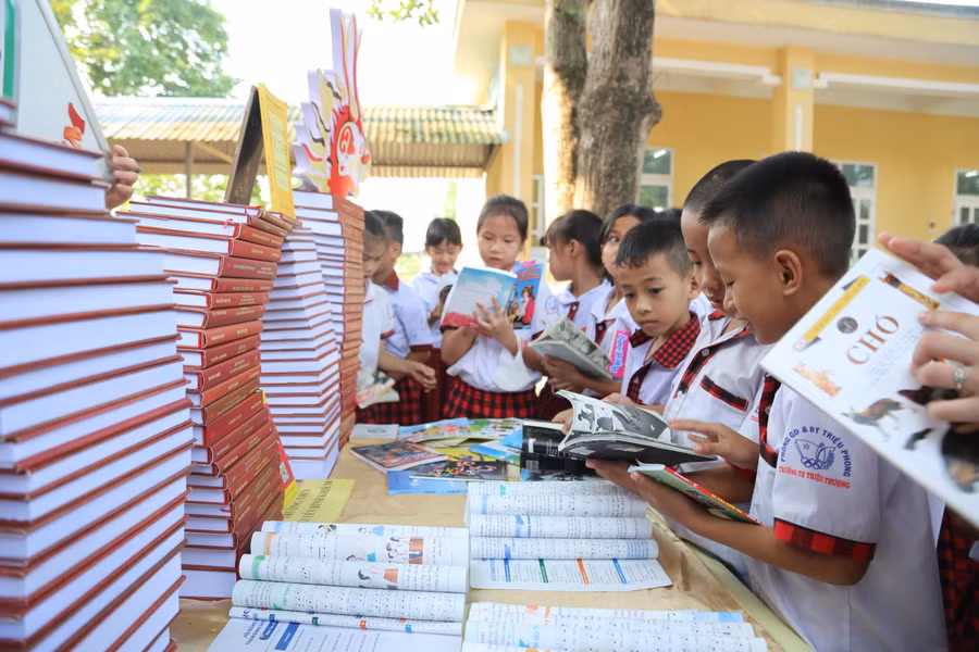 Các em học sinh chăm chú tham quan đọc sách tại các gian trưng bày.