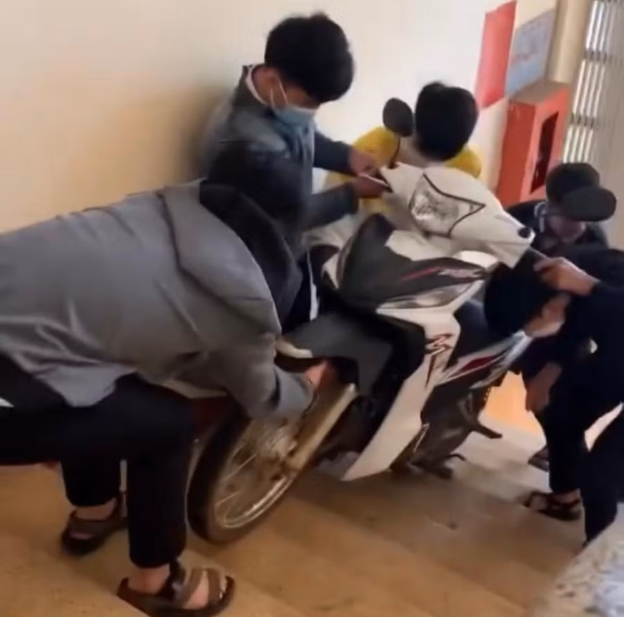 Đứa kéo, đứa đẩy, đứa bưng ... tất cả mục đích mang được xe thầy lên tầng 3 (ảnh cắt từ clip).