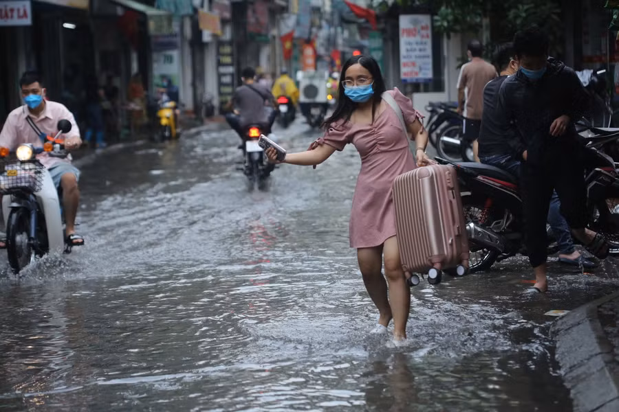 Nhiều người phải đi bộ ra ngoài đoạn đường khô ráo để bắt xe.