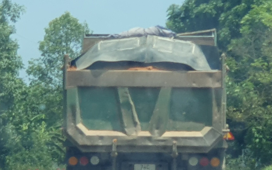 Một chiếc xe tải đầy ắp chở đất rời khỏi hiện trường. Một chiếc xe tải đầy ắp chở đất rời khỏi hiện trường.