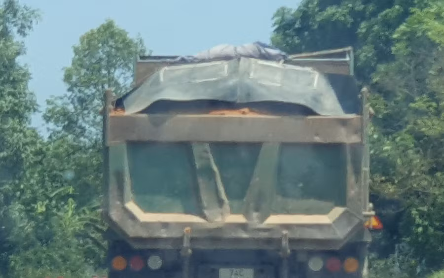 Một chiếc xe tải đầy ắp chở đất rời khỏi hiện trường. Một chiếc xe tải đầy ắp chở đất rời khỏi hiện trường.