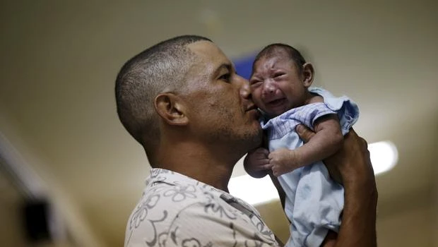 
Một người đàn ông ôm đứa con bị bệnh đầu nhỏ tại Bệnh viện Oswaldo Cruz , Recife (Brazil). Ảnh:Reuters.