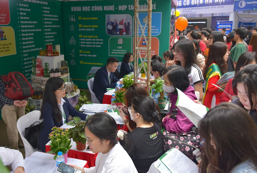 Phụ huynh, học sinh xếp hàng để được tư vấn tại gian hàng của Học viện Nông nghiệp Việt Nam - sáng 17/3.