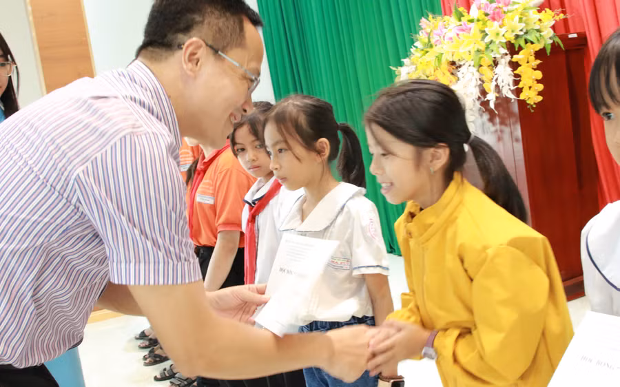 Học có hoàn cảnh khó khăn nhưng vươn lên trong học tập đón nhận học bổng từ NXBGD Việt Nam. (Ảnh: TT)