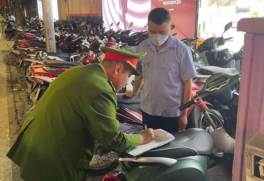 Lực lượng chức năng lập biên bản xử lý bãi trông xe thu giá trên giá niêm yết.