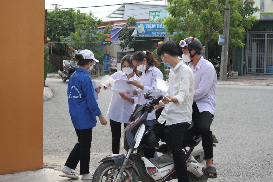 Tình nguyện viên hỗ trợ các thí sinh trước khi vào điểm thi.