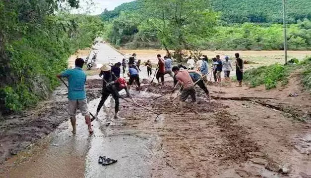 Giáo viên tham gia dọn bùn sau trận mưa lớn.