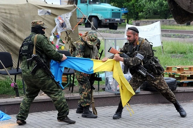 Các phần tử ly khai xé rách lá cờ Ukraine ở bên ngoài tòa nhà chính quyền khu vực ở Donetsk. (Nguồn: AFP)