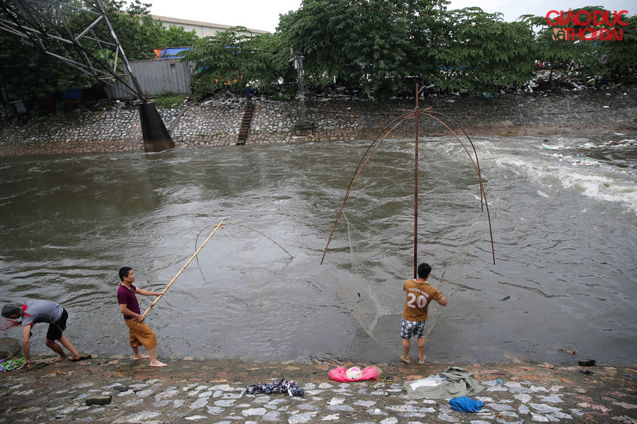 Ngay từ sáng nhiều người dân đã mang vó ra sông Kim Ngưu, điểm tại nhiều cửa xả để bắt cá