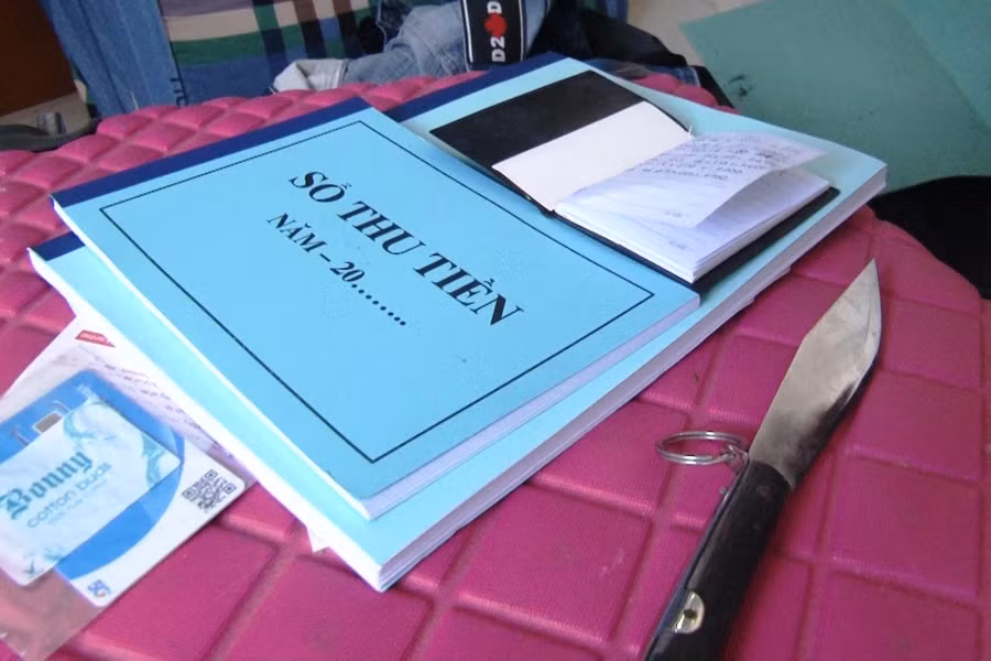 Sổ thu tiền và dao nhọn tại nơi ở của đối tượng Anh.