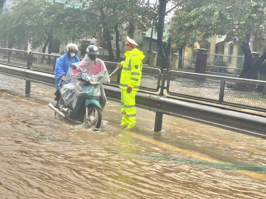 Người dân đi xe máy được CSGT hướng dẫn tắt máy, dắt qua dòng nước ở những đoạn thấp để nước lũ không vào ống pô gây chết máy xe. Người dân đi xe máy được CSGT hướng dẫn tắt máy, dắt qua dòng nước ở những đoạn thấp để nước lũ không vào ống pô gây chết máy xe.