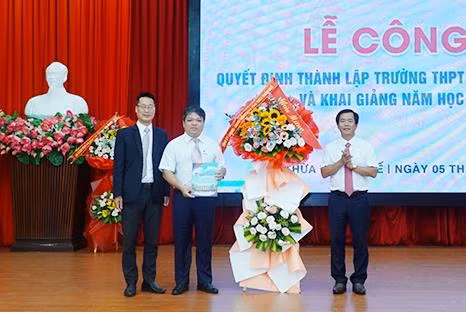 Ông Nguyễn Văn Phương - Chủ tịch UBND tỉnh Thừa Thiên - Huế (bên phải) tặng hoa chúc mừng nhà trường.