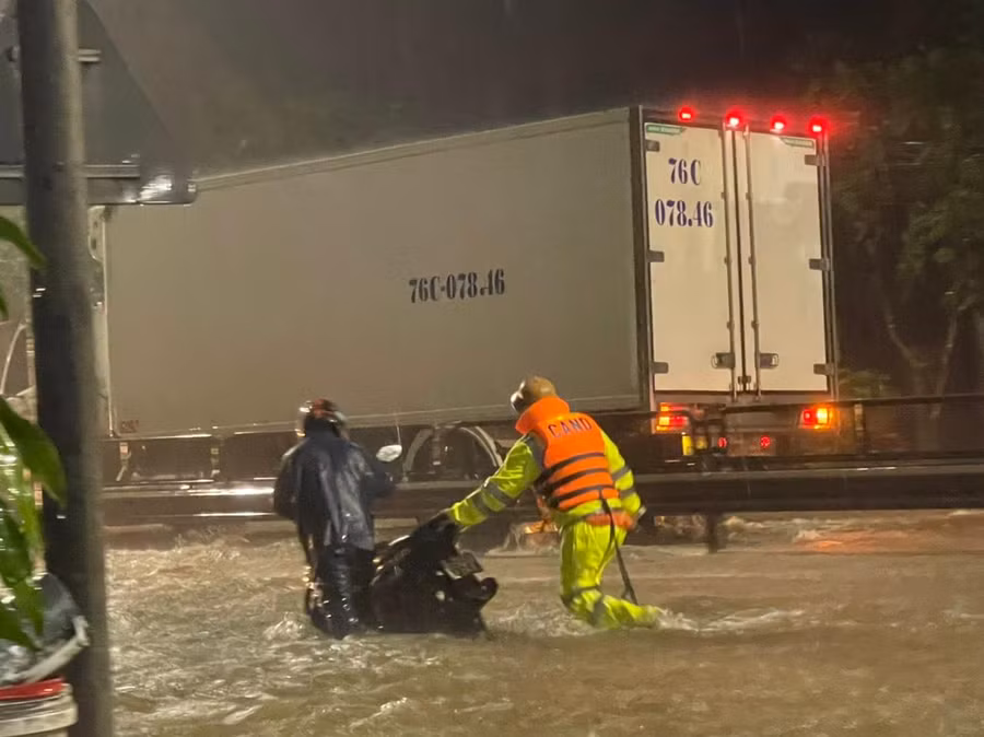 Trước giờ cấm, một số phương tiện được cảnh sát giúp vượt qua dòng nước lũ.