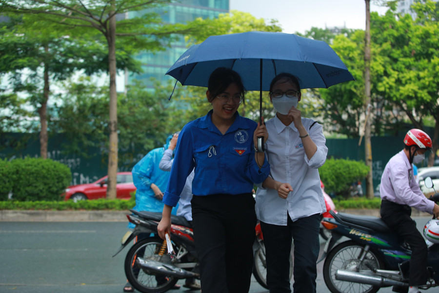 Lực lượng tình nguyện viên tại điểm thi đã mang ô để che cho các thí sinh vào trong phòng thi.