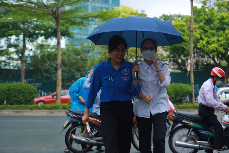 Lực lượng tình nguyện viên tại điểm thi đã mang ô để che cho các thí sinh vào trong phòng thi.