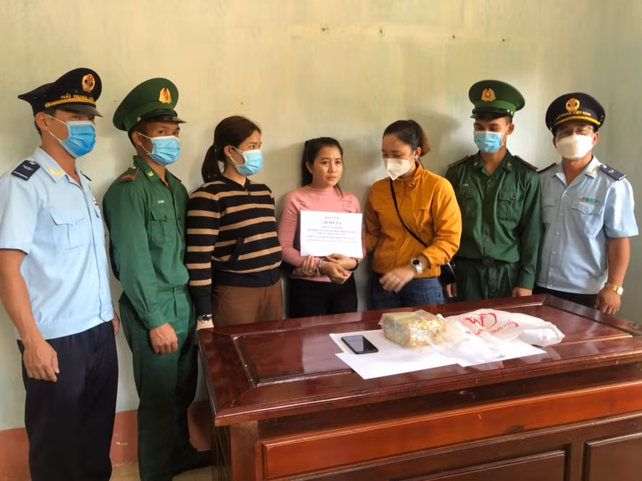 Nang Xi Sup La (áo hồng) cùng tang vật.