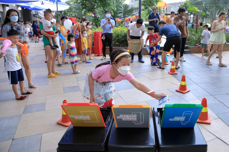 Các em hào hứng với trò chơi vượt chướng ngại vật thảy chai lọ vào thùng.