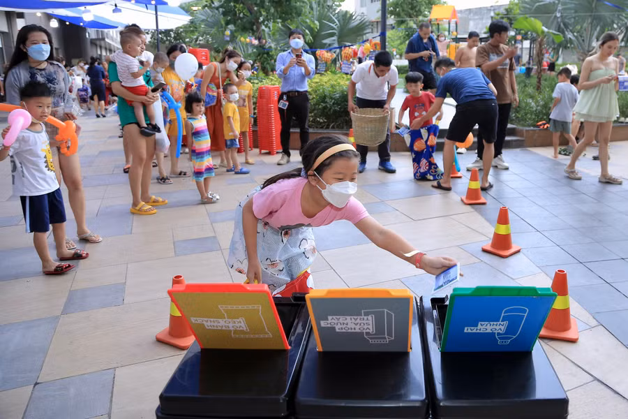 Các em hào hứng với trò chơi vượt chướng ngại vật thảy chai lọ vào thùng.