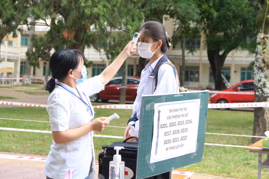 Thí sinh được đo thân nhiệt và đi theo từng luồng riêng biệt khi vào phòng thi. Ảnh: Dung Nguyễn.