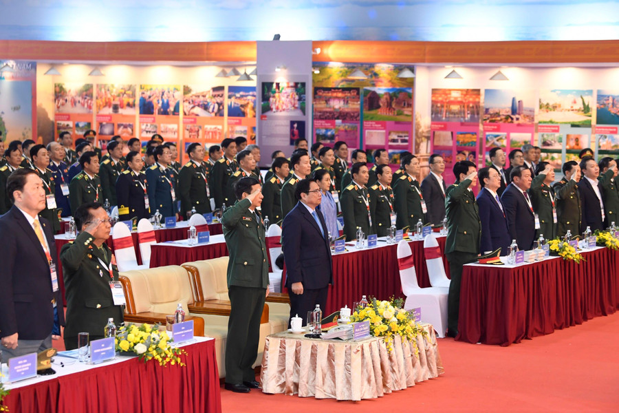 Các đại biểu dự khai mạc triển lãm thực hiện nghi thức chào cờ.