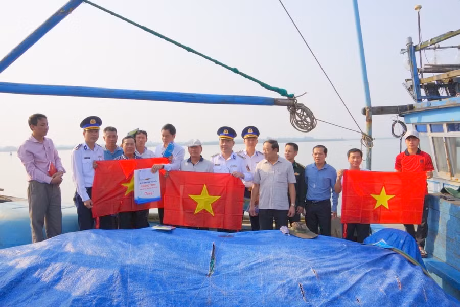 Đại diện Bộ Tư lệnh Vùng Cảnh sát biển 2 và Ban Dân vận Tỉnh ủy Quảng Trị trao tặng quà, cờ Tổ quốc cho các chủ phương tiện đánh bắt hải sản.