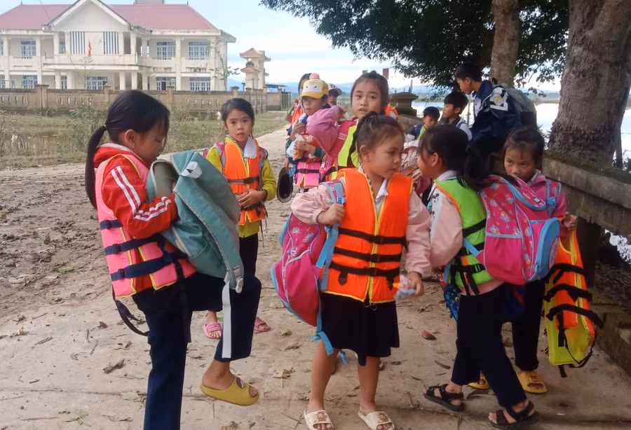 Các em học sinh vùng lũ vượt khó khăn đến trường.