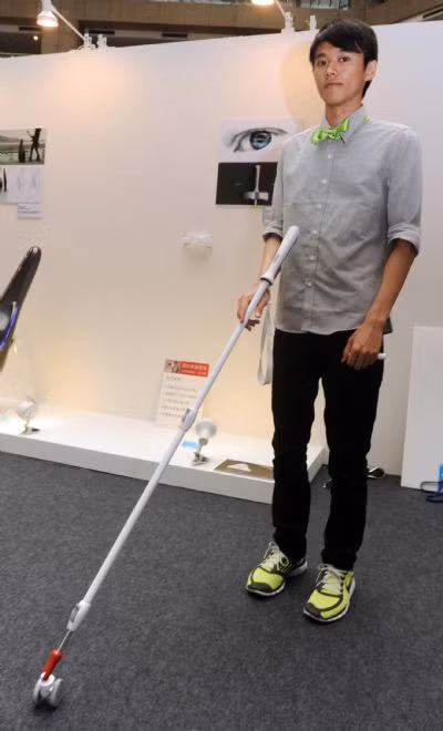 A staff worker shows a blind man leading stick