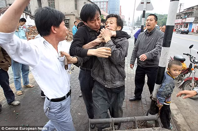 Onlookers became outraged at the auction and began to attack Yong Tsui, centre, who was caught in a head lock by another man Read more: http://www.dailymail.co.uk/news/worldnews/article-1281541/Chinese-boy-chained-lamp-post-father-tried-sell-street.html#ixzz0p3NCrm9Q