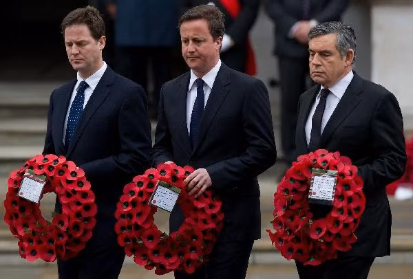 Britain’s Prime Minister Gordon Brown, right, with Conservative Party leader David Cameron and Liberal Democrat party leader Nick Clegg, left, hold their wreaths as they arrive at a service to commemorate the 65th anniversary of the end of World War II in Europe, at the Cenotaph in London, Saturday, May, 8 2010