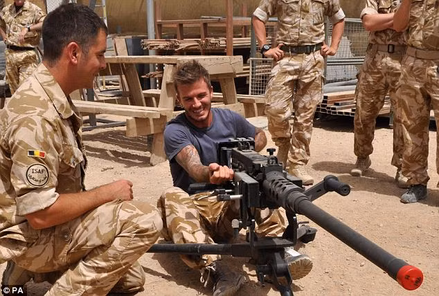 Beckham tests out a heavy machine gun as soldiers look on Read more: http://www.dailymail.co.uk/news/worldnews/article-1280468/David-Beckham-hails-amazing-troops-visit-Afghanistan.html#ixzz0olR7UZ8b