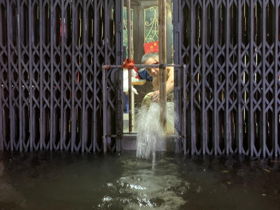 Nước cao tràn vào nhà người dân, khi ngớt mưa người dân phải dùng xô để tát nước ra bên ngoài.