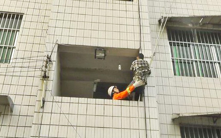 A burglar had to be rescued by firefighters after getting trapped outside 4th floor window, Nanning, Guangxi Province, China. The man in question sneaked into the village at midnight, but was discovered when he attempted to break into a flat. Pursued by the occupants, he climbed out of a 4th floor window and threatened to jump. Locals called the emergency services and the man had to be rescued by firefighters before being taken away by police.
