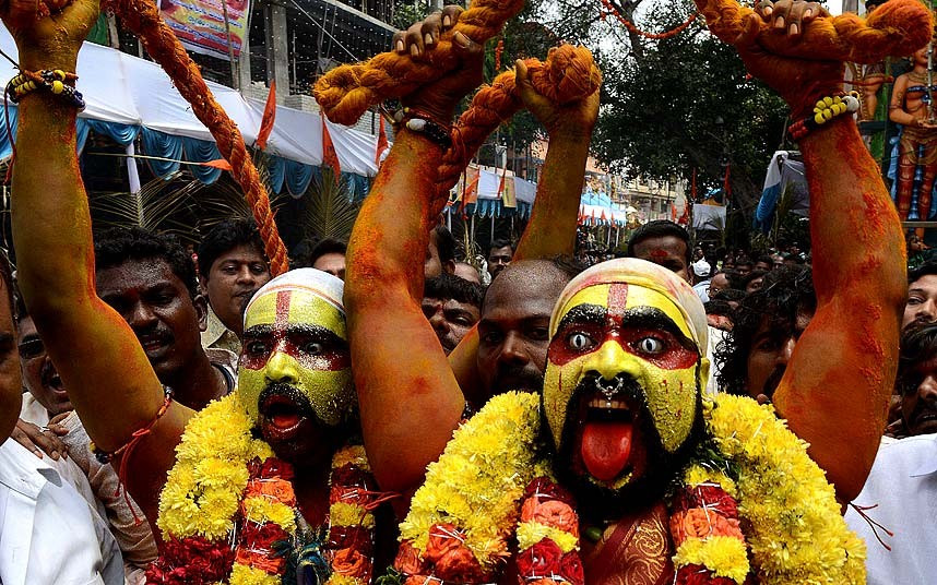 Indian Hindu devotees representing Potharaju, brother of the goddess Mahankali, dance in the streets during the Bonalu festival at the Sri Ujjaini Mahakali Temple in Secunderabad, India.