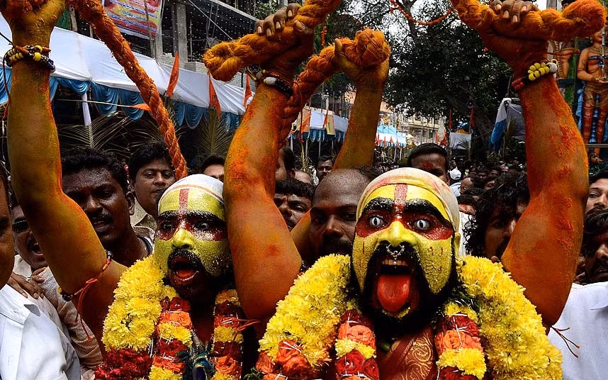Indian Hindu devotees representing Potharaju, brother of the goddess Mahankali, dance in the streets during the Bonalu festival at the Sri Ujjaini Mahakali Temple in Secunderabad, India.
