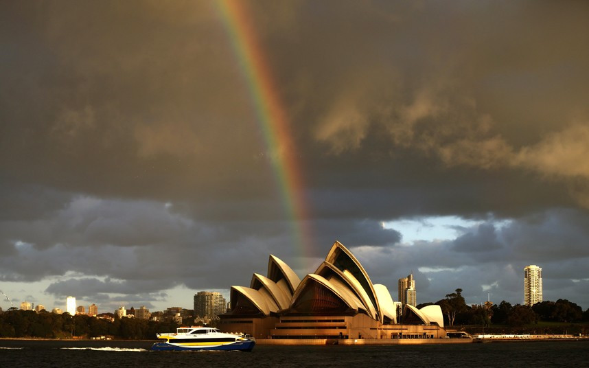A passenger ferry navigates past the Sydney Opera House, as a rainbow is seen in the sky, on a sunny winter afternoon in central Sydney. Sydney has experienced one of the warmest Julys on record with average daytime temperature of more than 19 degrees Celsius (66 degrees Fahrenheit).