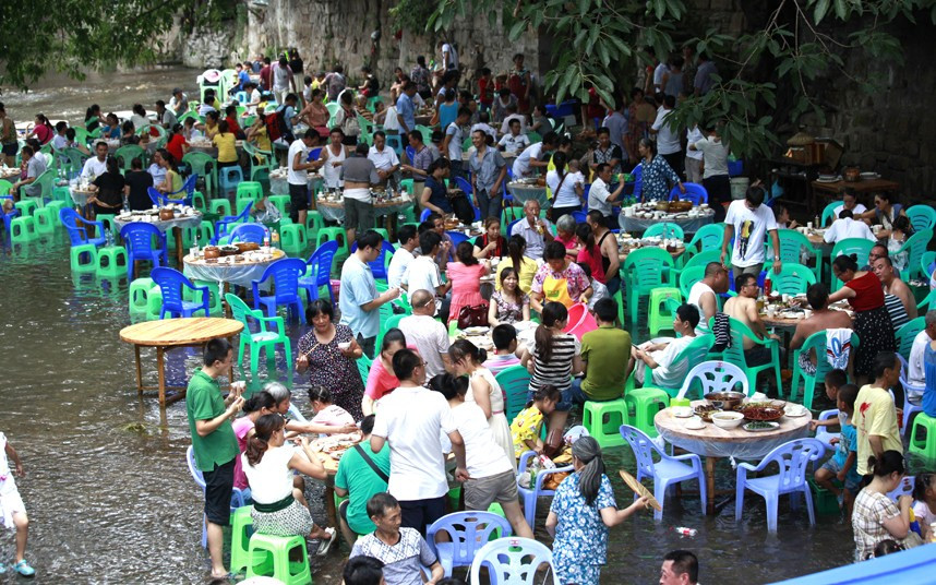 The aptly named the River Cafe in Chongqing, China, has come up with an ingenious way of attracting customers. Taking advantage of a nearby stream, the owners have set up dozens of tables straight in the water, offering patrons a cool escape from the heat. With summer temperatures reaching over 40 degrees Celsius, the Chinese are always looking for new and enjoyable ways to cool off. The River Cafe is inviting locals and tourists to take off their shoes and grab a seat in the water. The pop-up restaurant now has more tables in the stream than on land and can seat up to 300 people at a time.