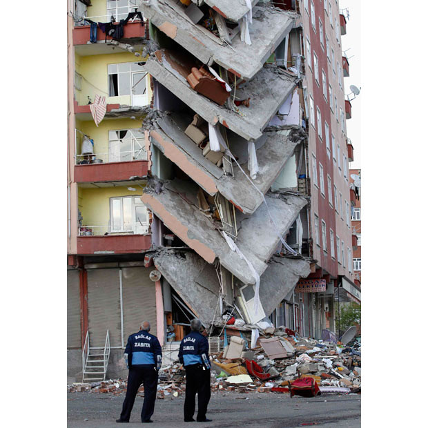 Municipal officers stand guard in front of a collapsed building in Diyarbakir, Kurdish-dominated southeastern Turkey. 28 families living in the building were evacuated by authorities last week after cracks began to form, leaving all their belongings behind. A part of the building collapsed the day after the evacuation. The reason for the collapse is not clear but shoddy construction, lack of building regulation and corruption have been blamed for past cases of building collapse in Turkey.