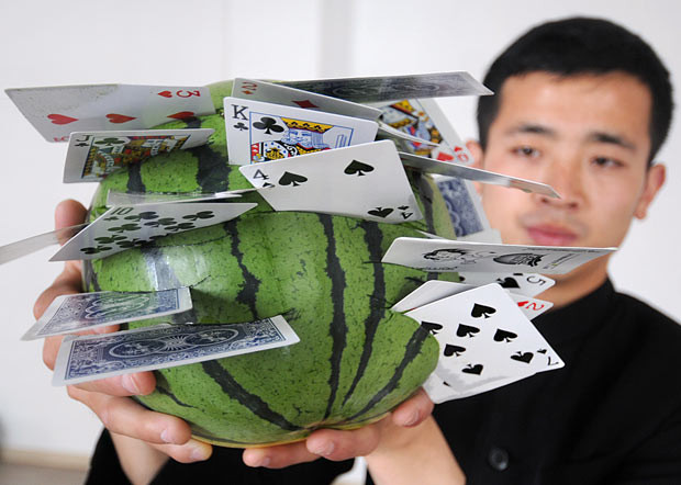 ...Standing three metres away from a watermelon, he can throw 28 cards so they become embedded in the fruit like knives. See video of him in action here: http://video.rexfeatures.com/Other/Man-Throws-Playing-Cards-Like/16987943_mmzm6h#1285177598_V3xNGMt