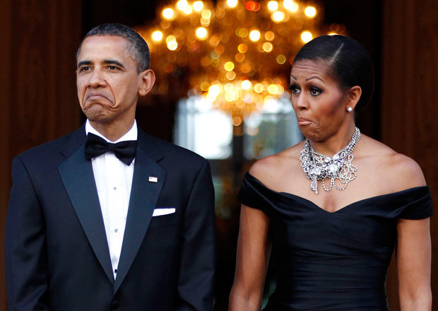 US President Barack Obama and first lady Michelle Obama react as the car carrying Queen Elizabeth and the Duke of Edinburgh arrives at Winfield House in London