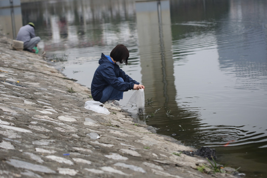 Nhiều người dân đến hồ Hoàng Cầu để thả cá chép tiễn ông Công ông Táo về trời